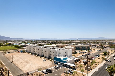 an aerial view of a large white building with a parking lot in front of it